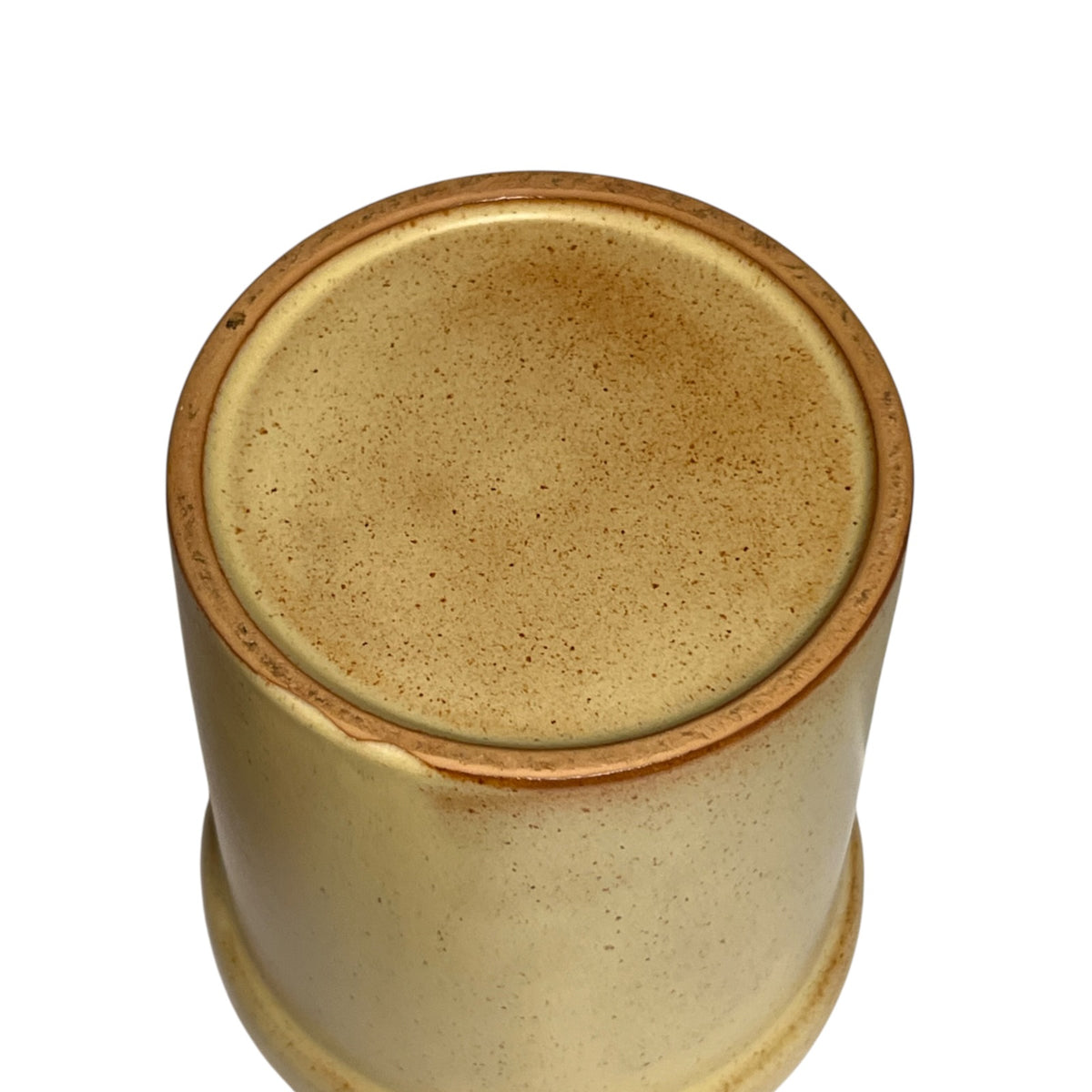 A close-up top-down view of a cylindrical ceramic planter or vase with a speckled beige and light brown glaze, set against a plain white background.