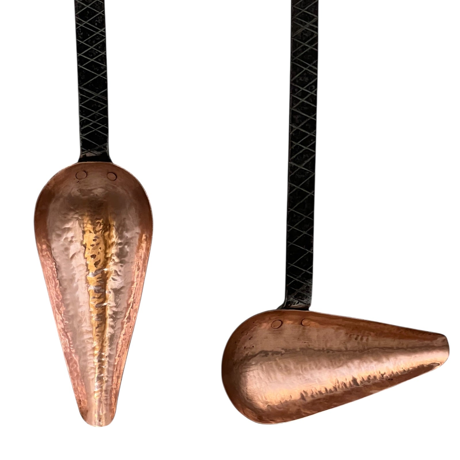 Close up of French copper kitchen utensils with black handles on a white background