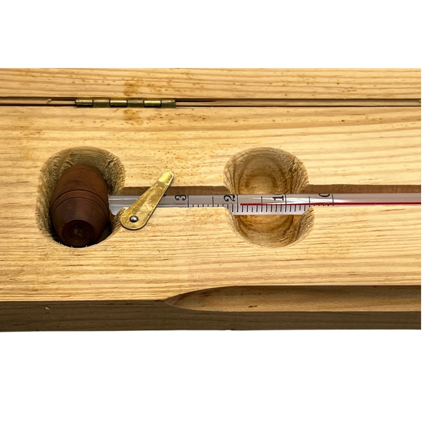Wooden instrument with a thermometer-like device on a white background