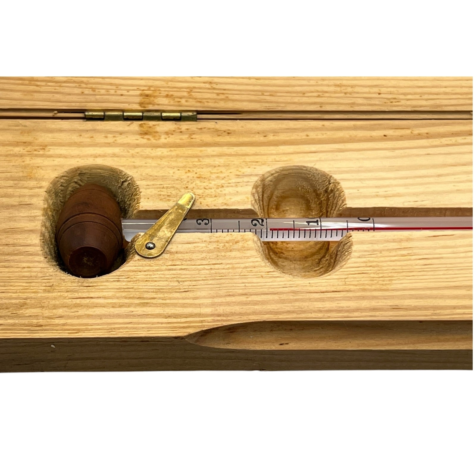 Wooden instrument with a thermometer-like device on a white background