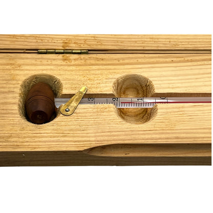 Wooden instrument with a thermometer-like device on a white background