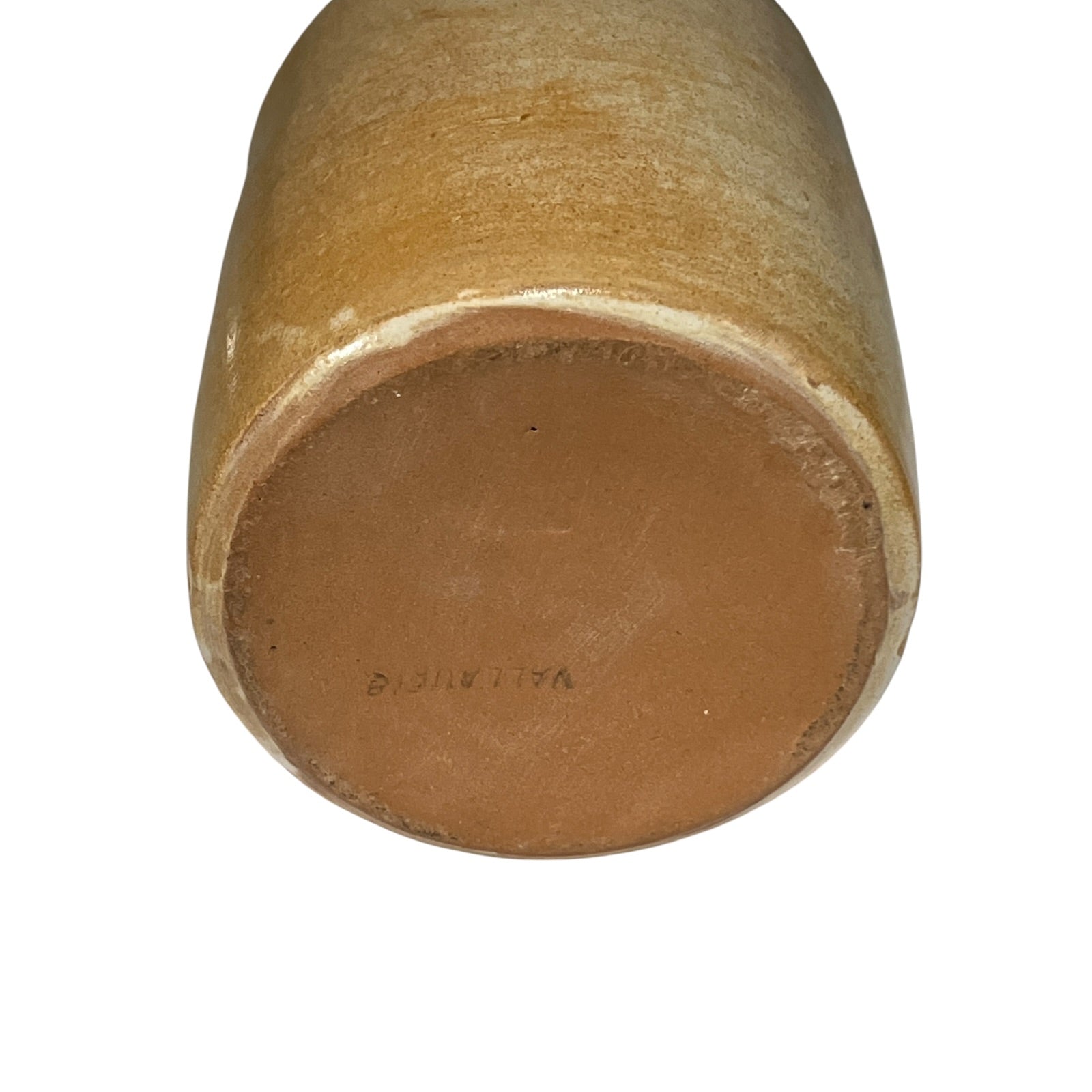 Close-up of the round bottom of a ceramic vase or planter, showing a smooth glazed finish in warm tan and brown tones against a plain white background.