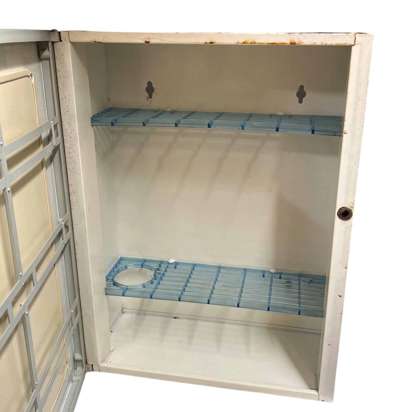 close up of a vintage metal bathroom cabinet inside view on a white background