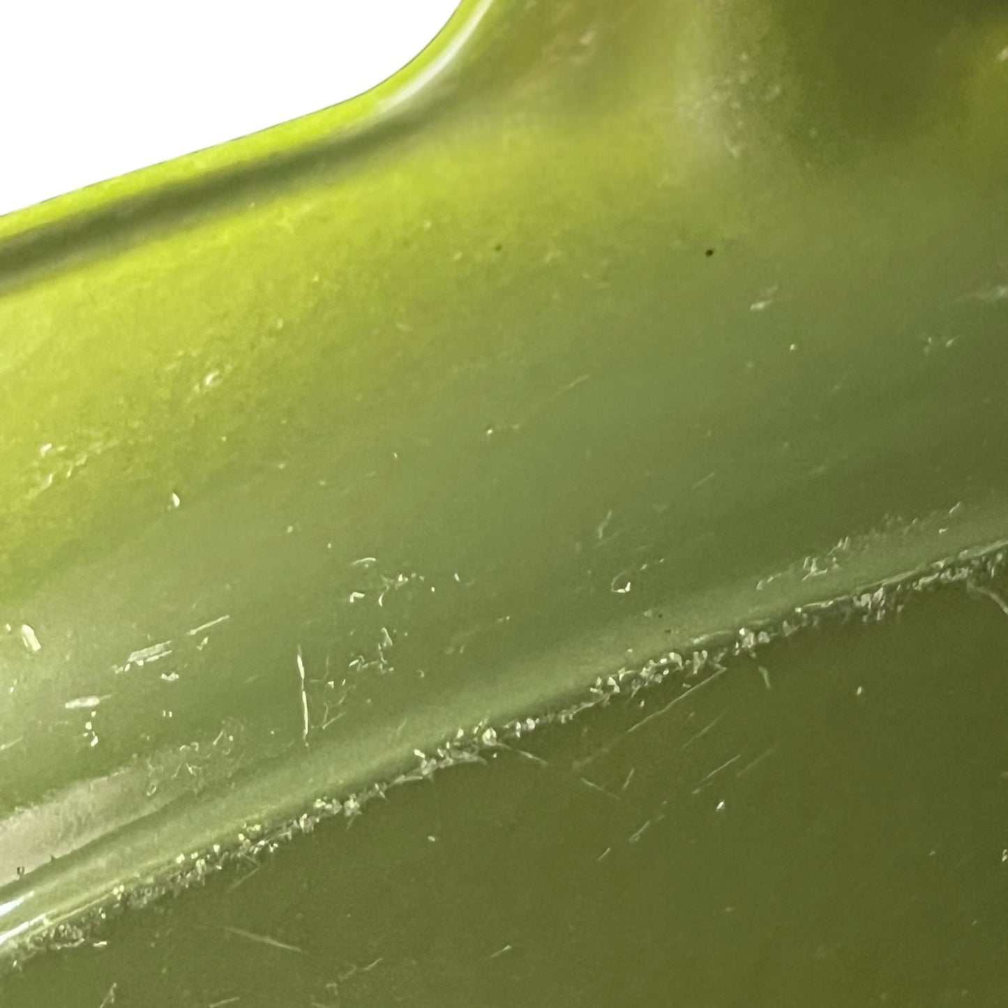 Close-up of a green Le Creuset cast iron skillet on a white background 