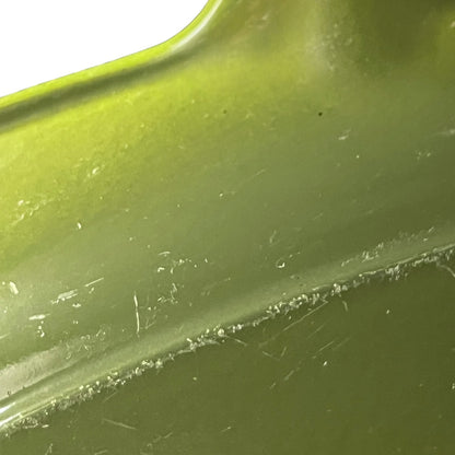 Close-up of a green Le Creuset cast iron skillet on a white background 