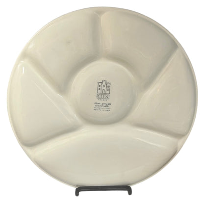 Close-up of a vintage fondue plate with detailed design on a white background