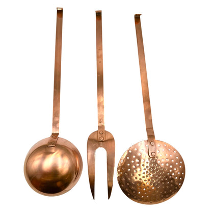 Set of three copper kitchen utensils on a white background
