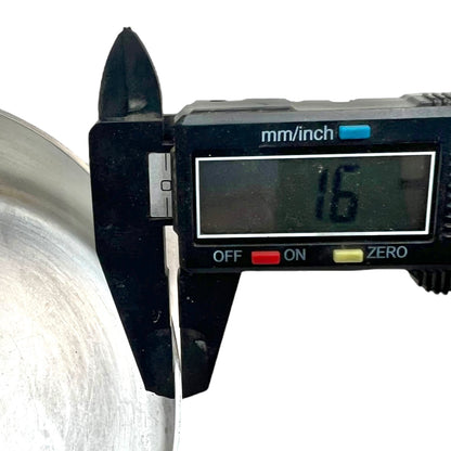 Digital calliper measuring the thickness of a copper pan with a digital display showing the measurement.