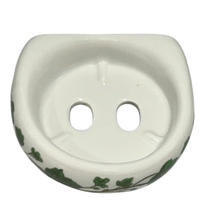Porcelain bathroom toothbrush holder  featuring green leaf patterns on a white background