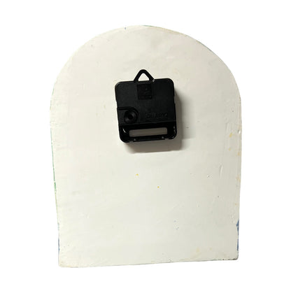 A black battery holder on a white clock, photographed against a plain white background.