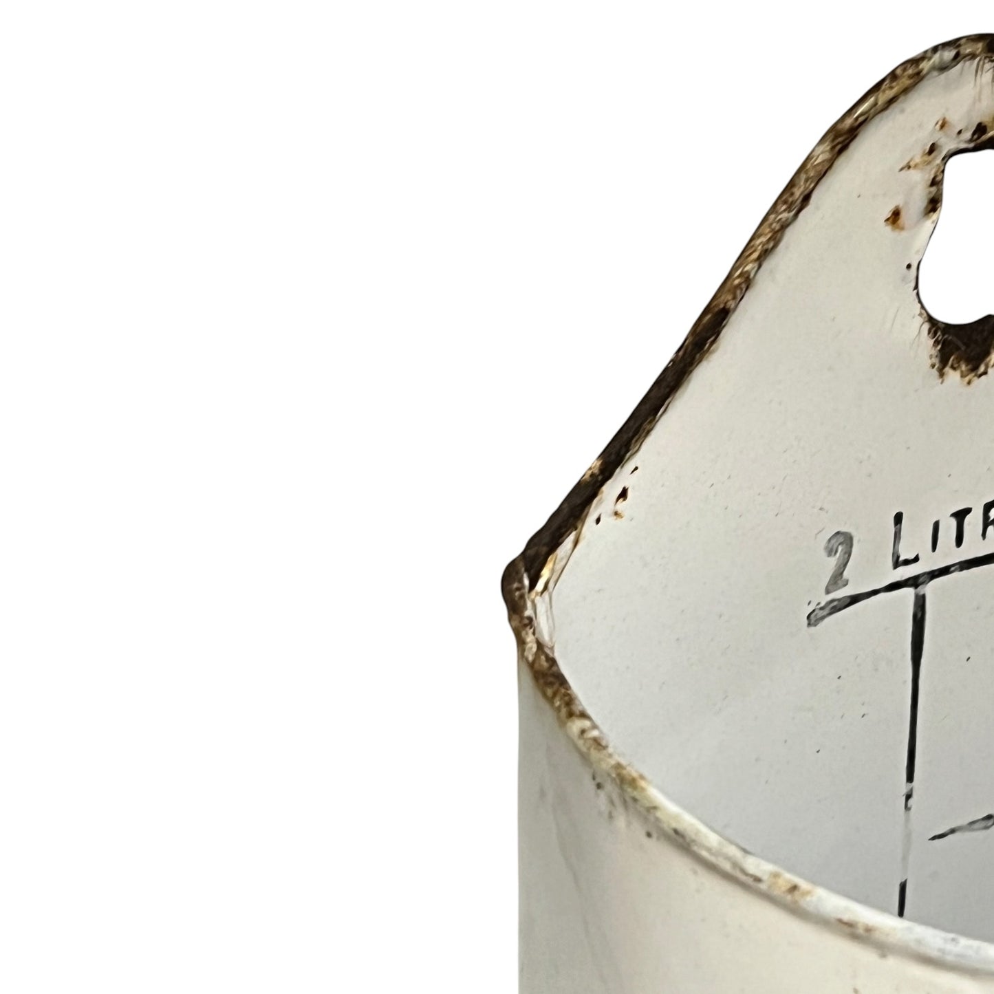 Close-up of a distressed white enamel measuring container with rusted edges and a hanging hole, showing a partial measurement marking of 2 liters on a plain white background.