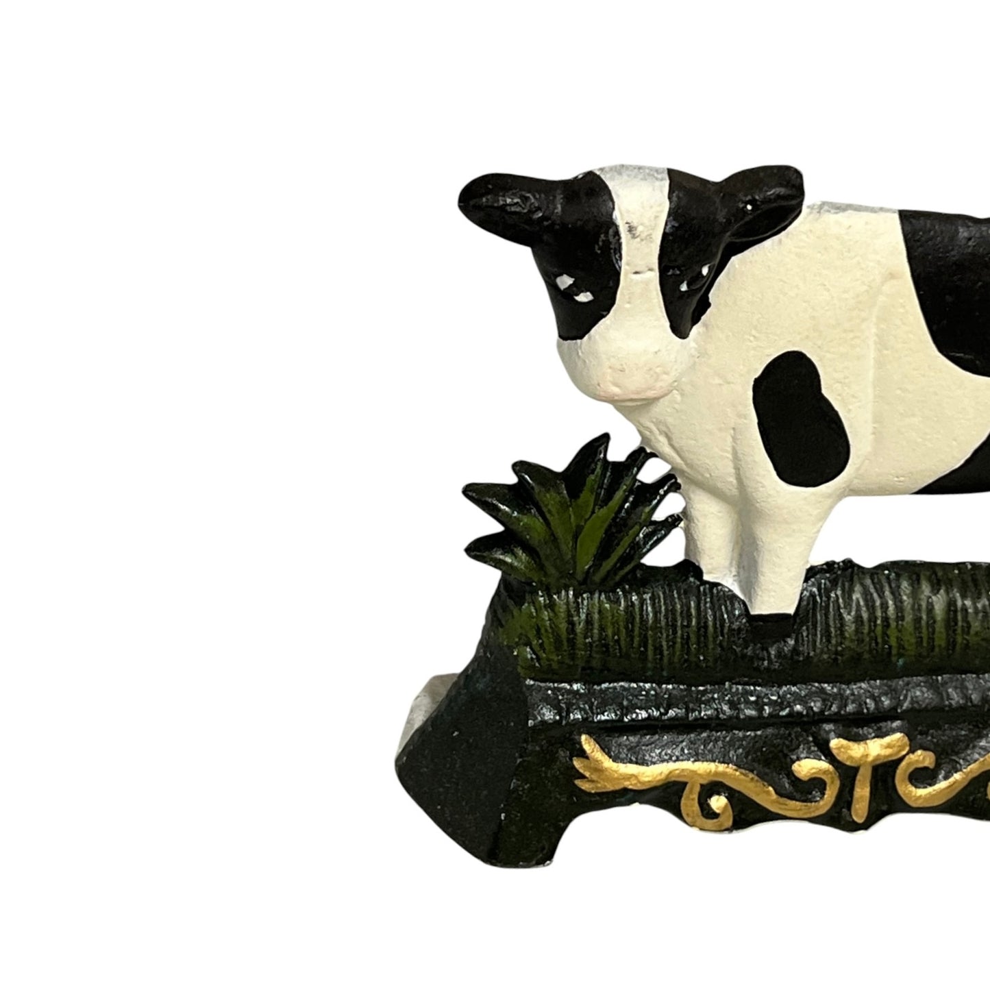Close up of small cow shaped cast iron doorstop on a white background