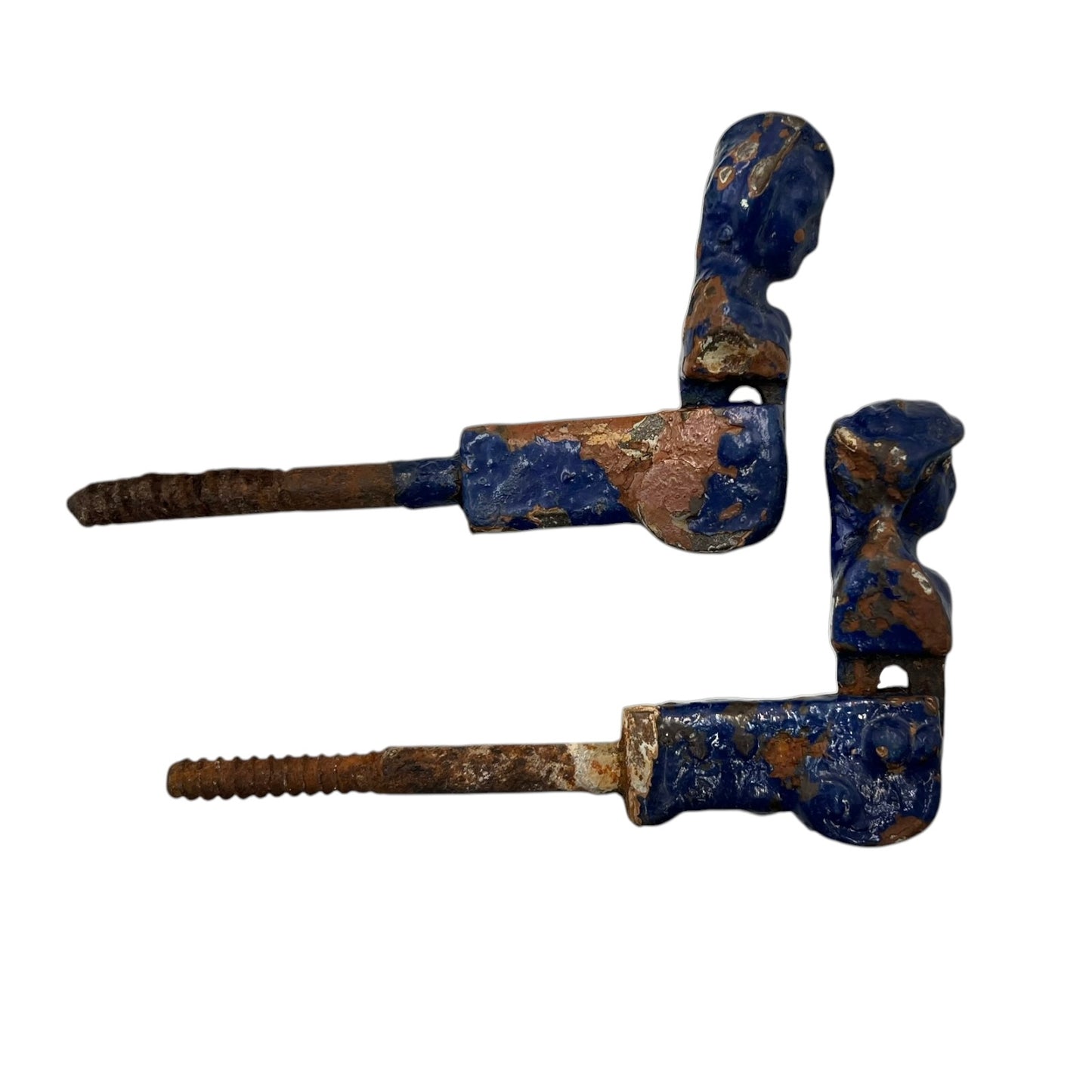 Pair of French cast iron shutter dogs painted blue with signs and age and wear on a white background
