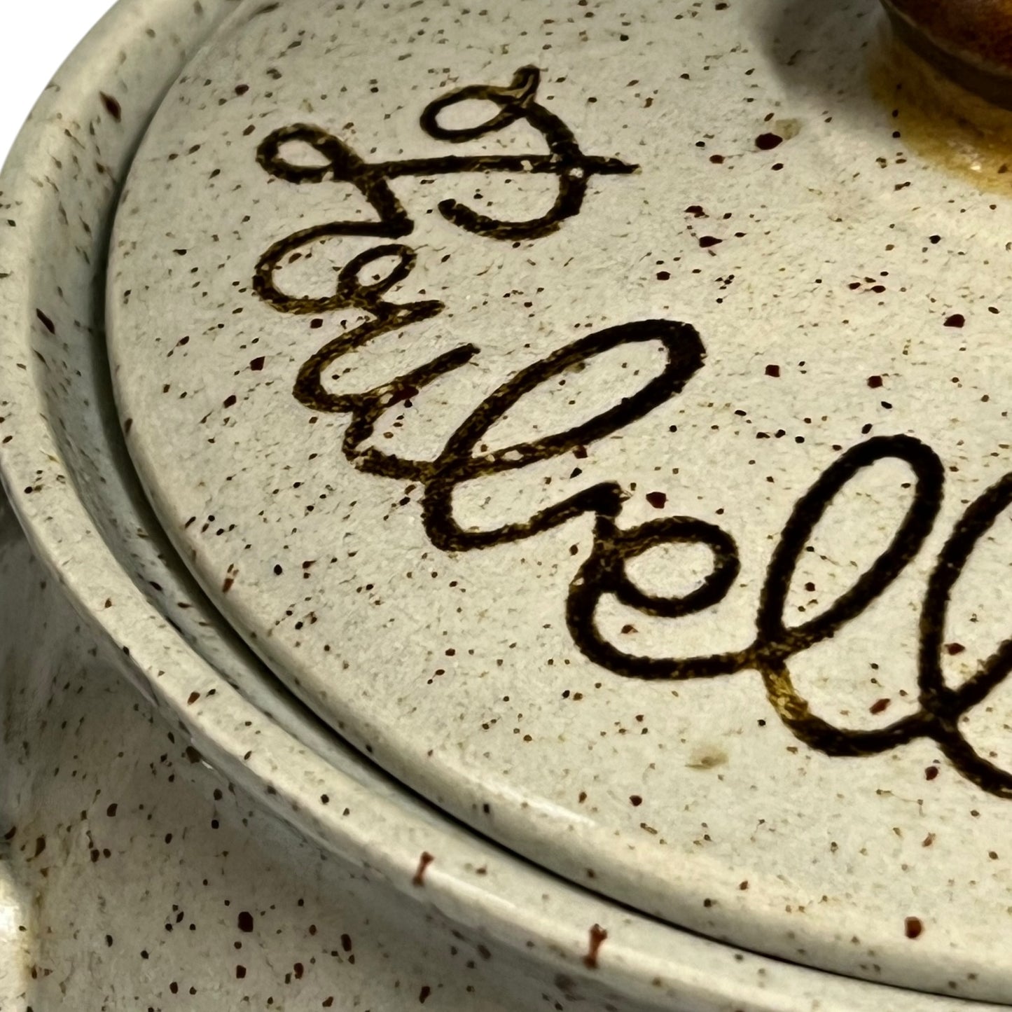 Close up of a speckled ceramic container on a white background