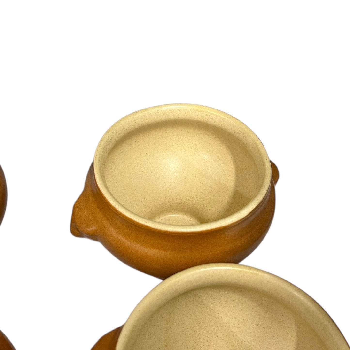 light brown ceramic French soup bowls with lions head handles on a white background 