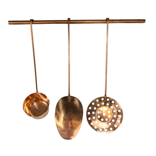Set of 3 copper utensils on a copper hanging bar on a white background