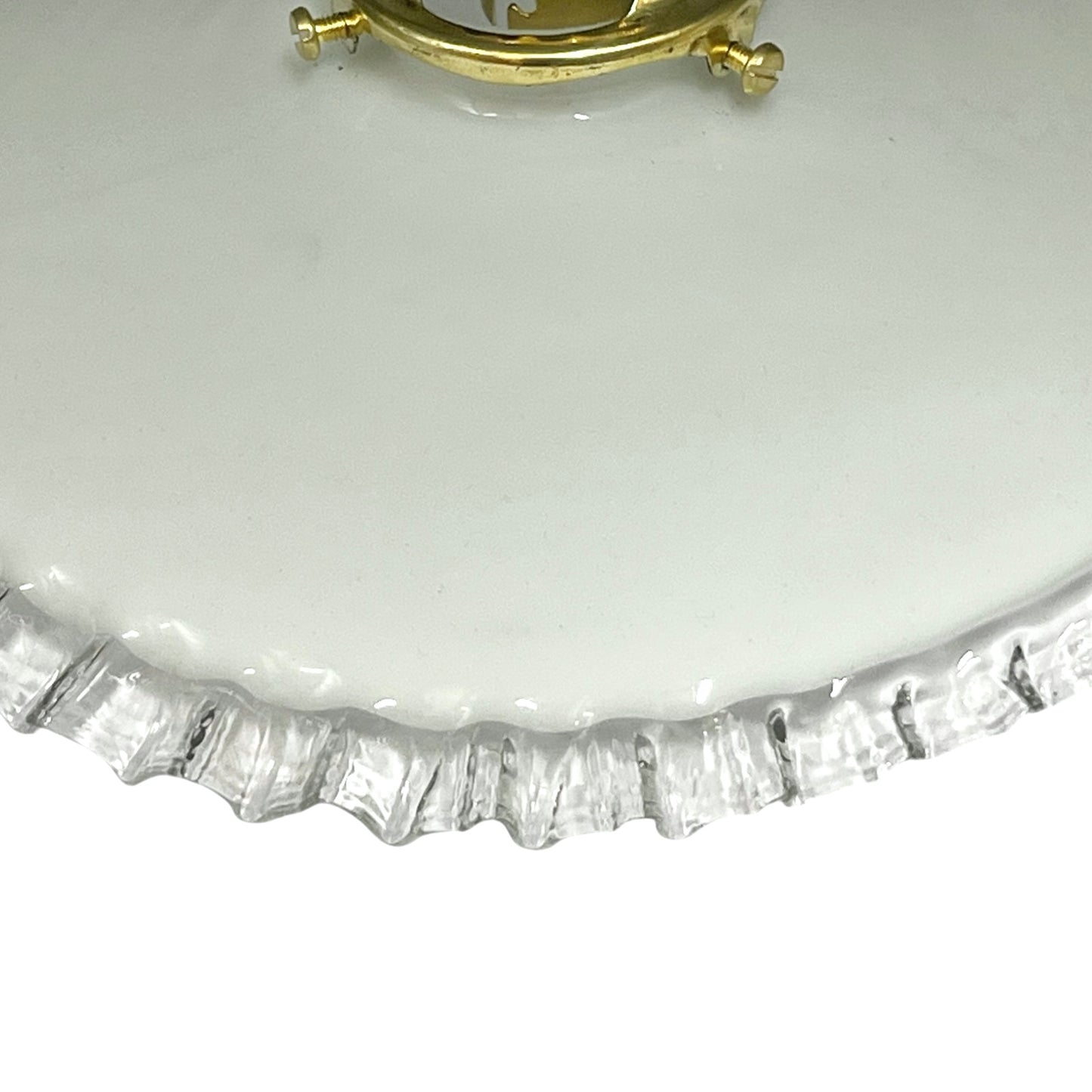 close up of brass ceiling light fixture with white glass shade on a white background