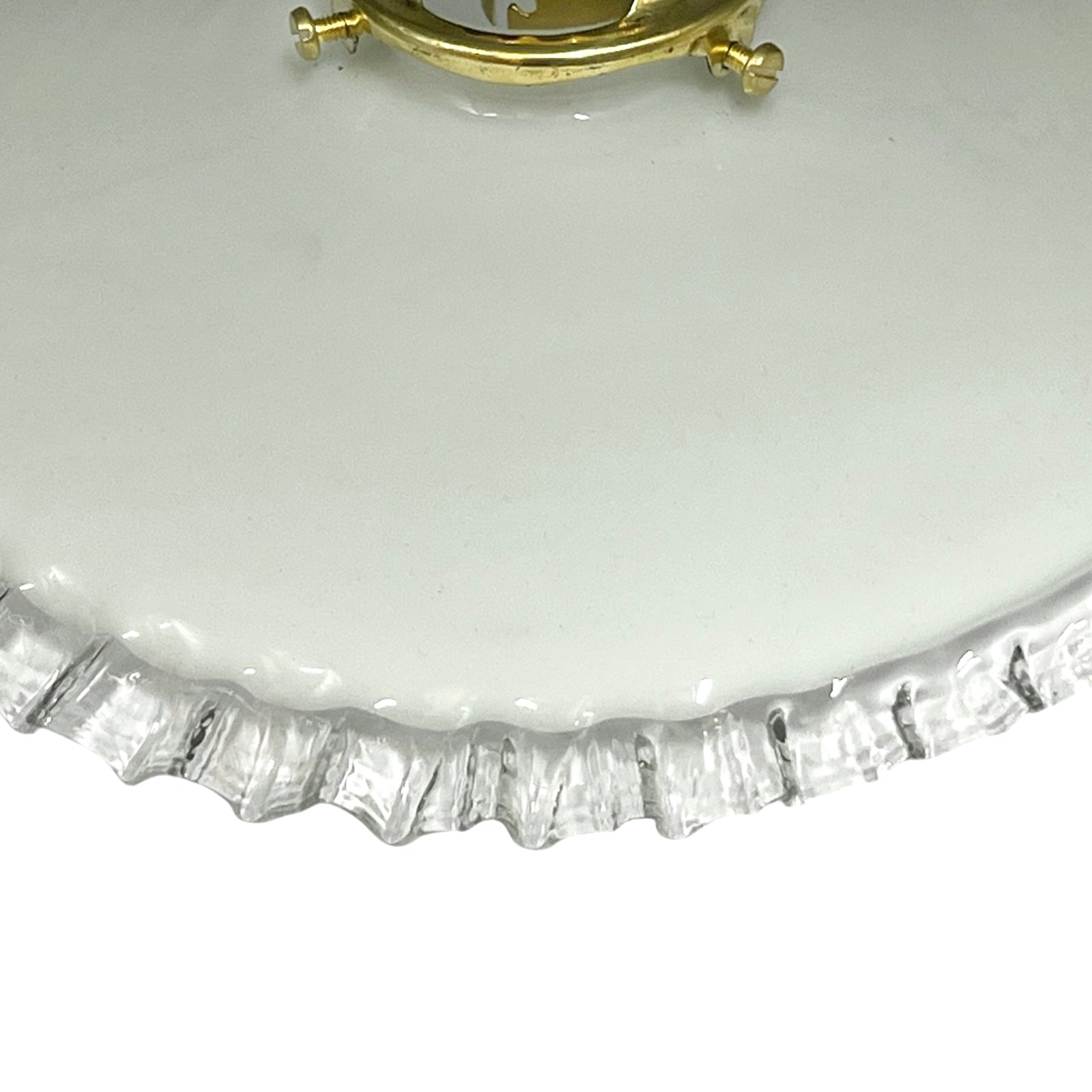 close up of brass ceiling light fixture with white glass shade on a white background