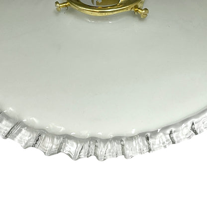 close up of brass ceiling light fixture with white glass shade on a white background