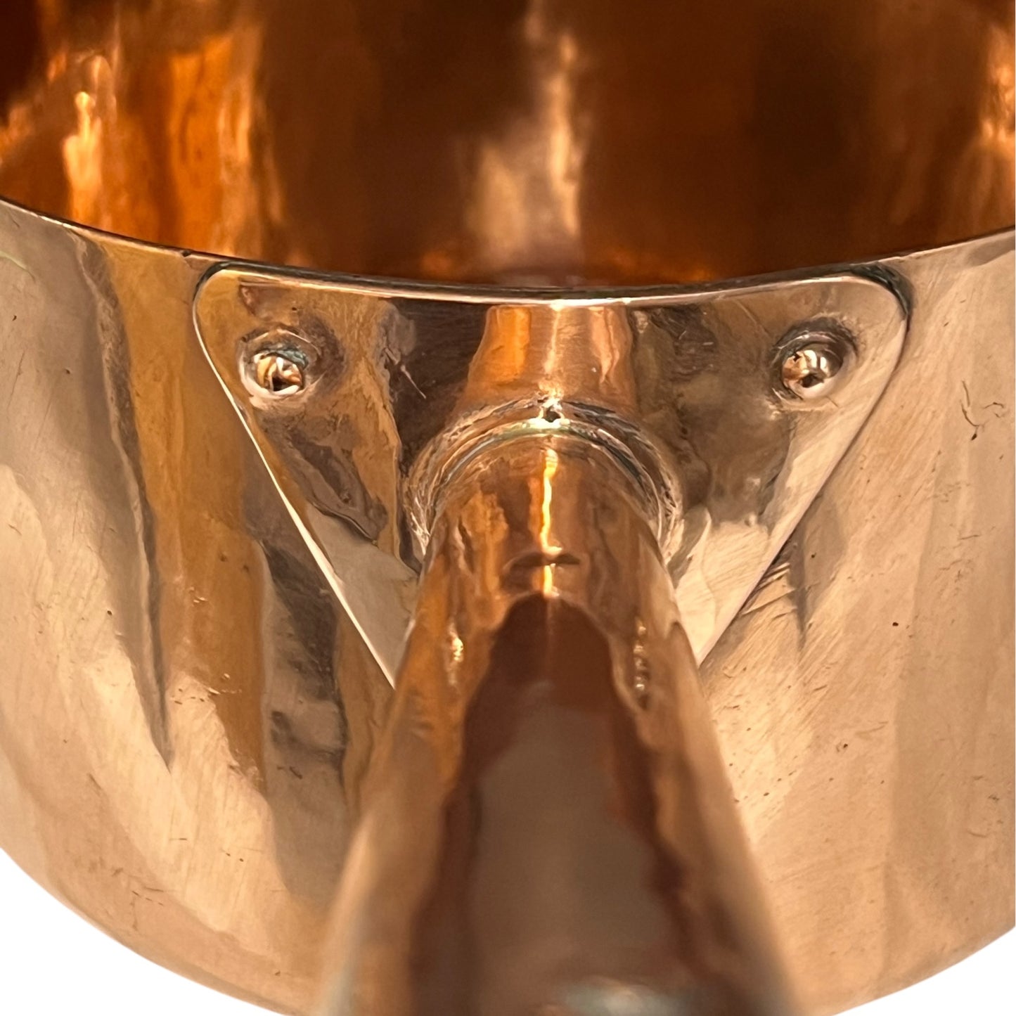 Close-up of a copper pot with a pouring spout on a white background