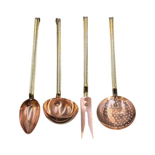 Set of four copper and brass kitchen utensils with long handles on a white background