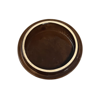 A round, dark brown ceramic jar lid with a glossy finish and a light beige inner rim, shown from a top-down perspective on a white background.