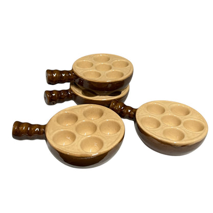4 ceramic snail dishes  with brown handles and beige baking cups, arranged on a plain white background.
