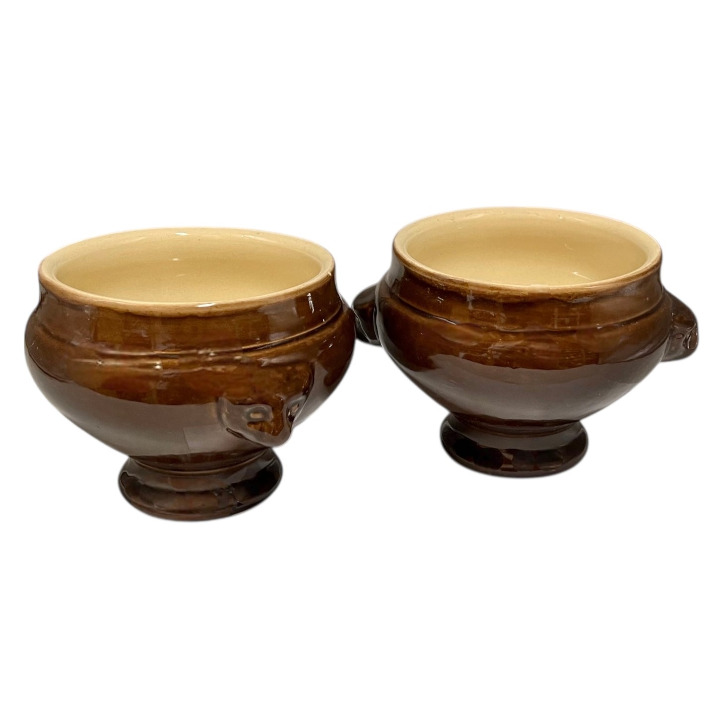 Two brown ceramic bowls with beige interior on a white background