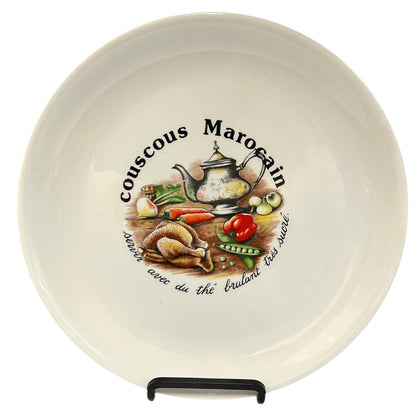 Ceramic plate with couscous Marocain design featuring a teapot and vegetables on a white background.