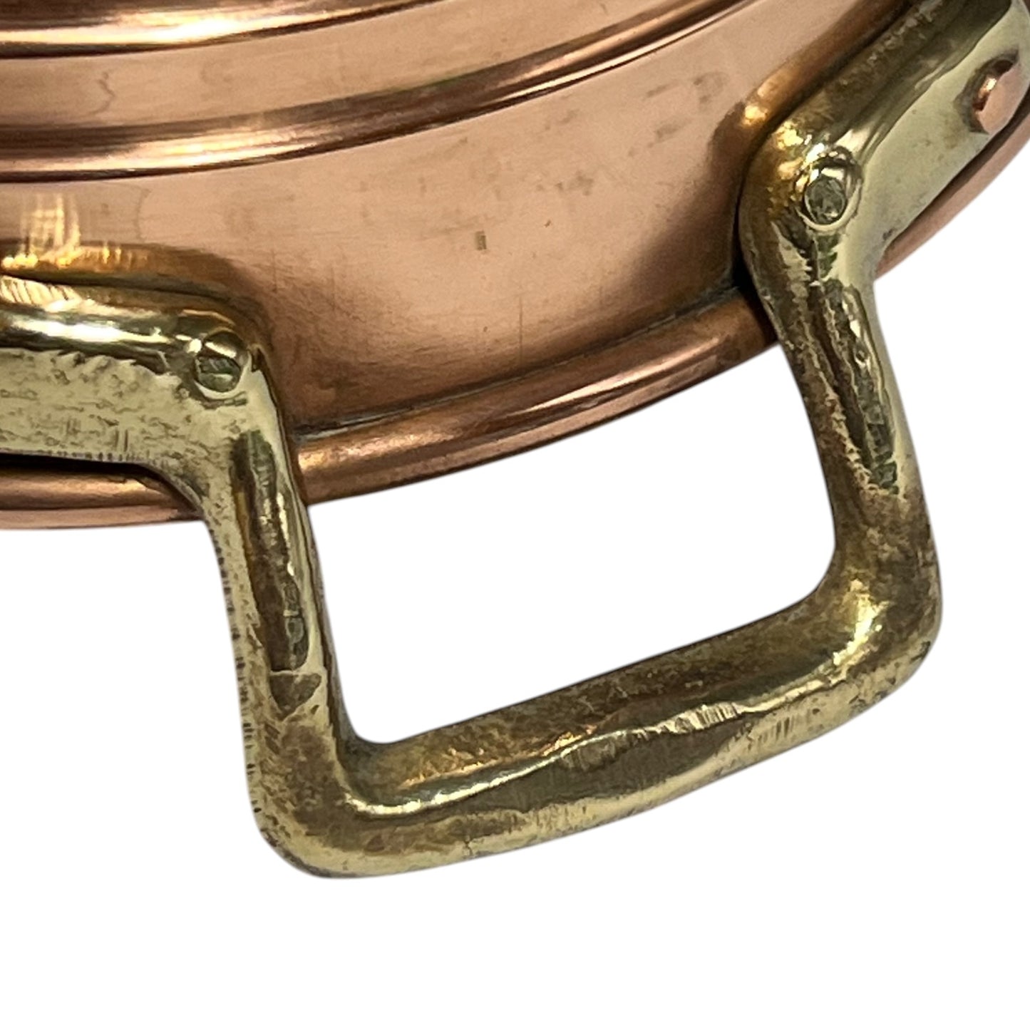 Close-up of a copper pot with a brass handle on a white background.