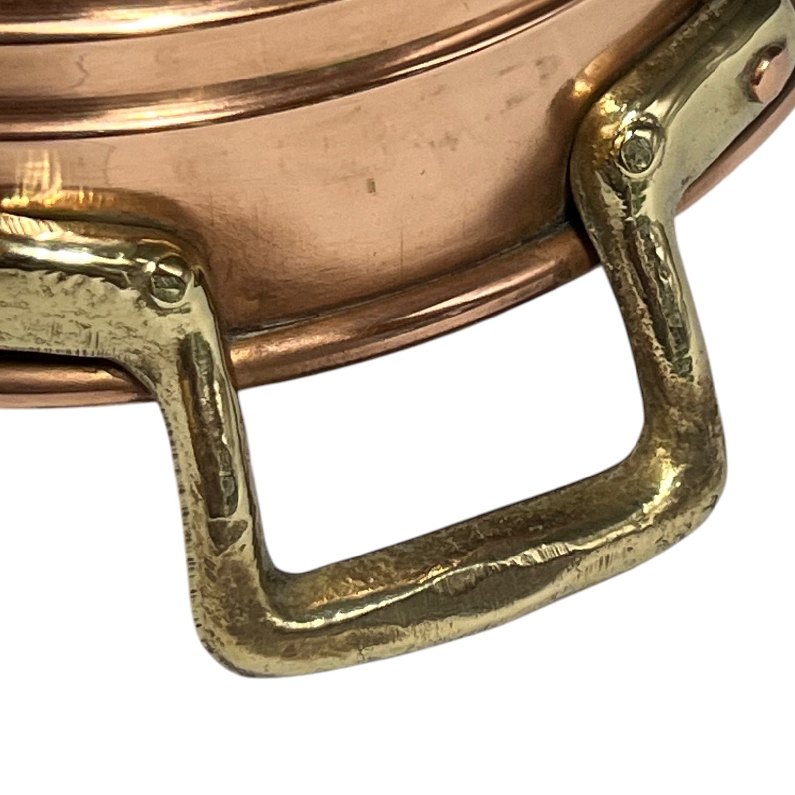 Close-up of a copper pot with a brass handle on a white background.