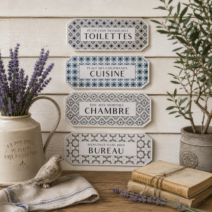 Decorative French wall signs on a wooden wall with plants and books.
