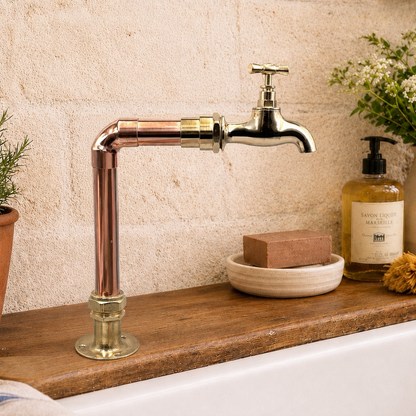 Copper and brass single pillar tap on a wooden countertop over a Belfast sink 