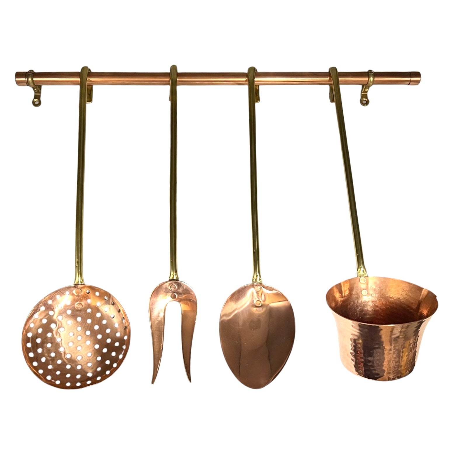 A set of 4 hammered and perforated copper kitchen utensils hanging from a matching copper rod against a plain white background.