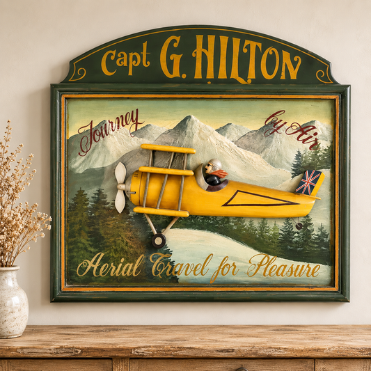 A framed vintage-style wall sign featuring a yellow biplane over a mountain landscape, with the text 'Capt. G Hilton.