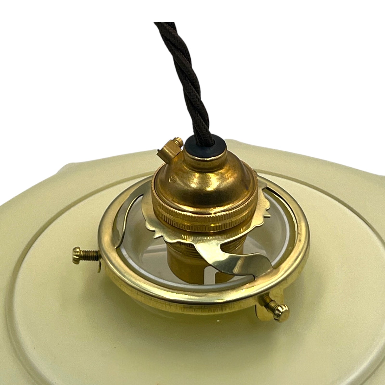 Close-up of a brass lamp fixture with a milk glass shade on a white background