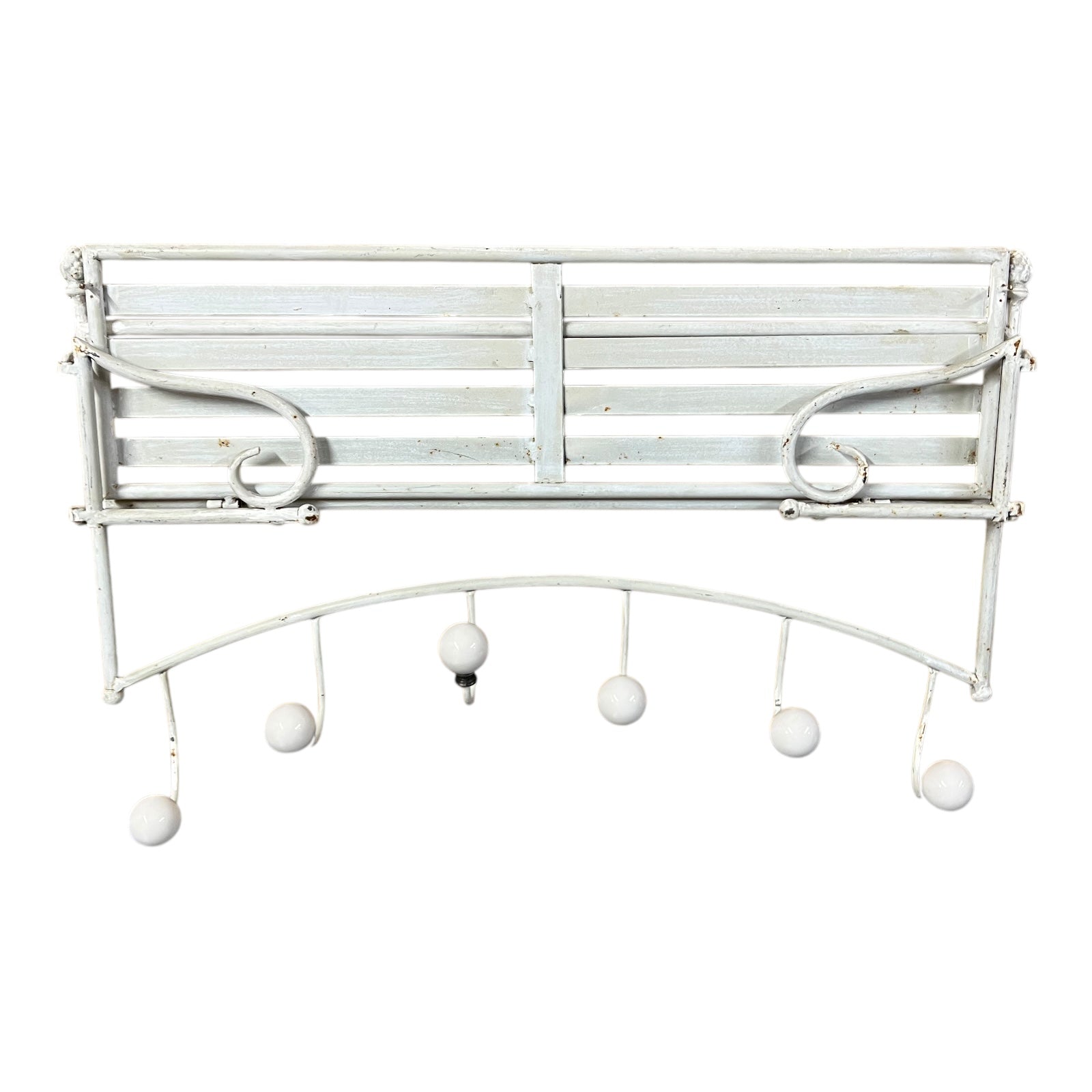 White metal wall-mounted coat rack with hanging balls on a white background