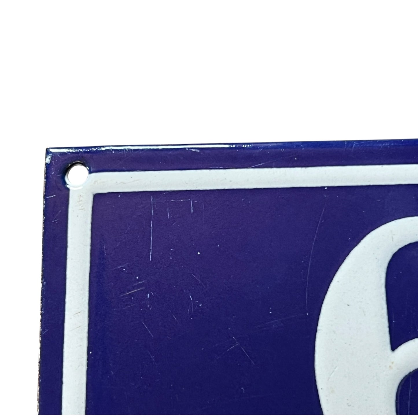 Close-up of a blue and white sign with a number '6' on a white background