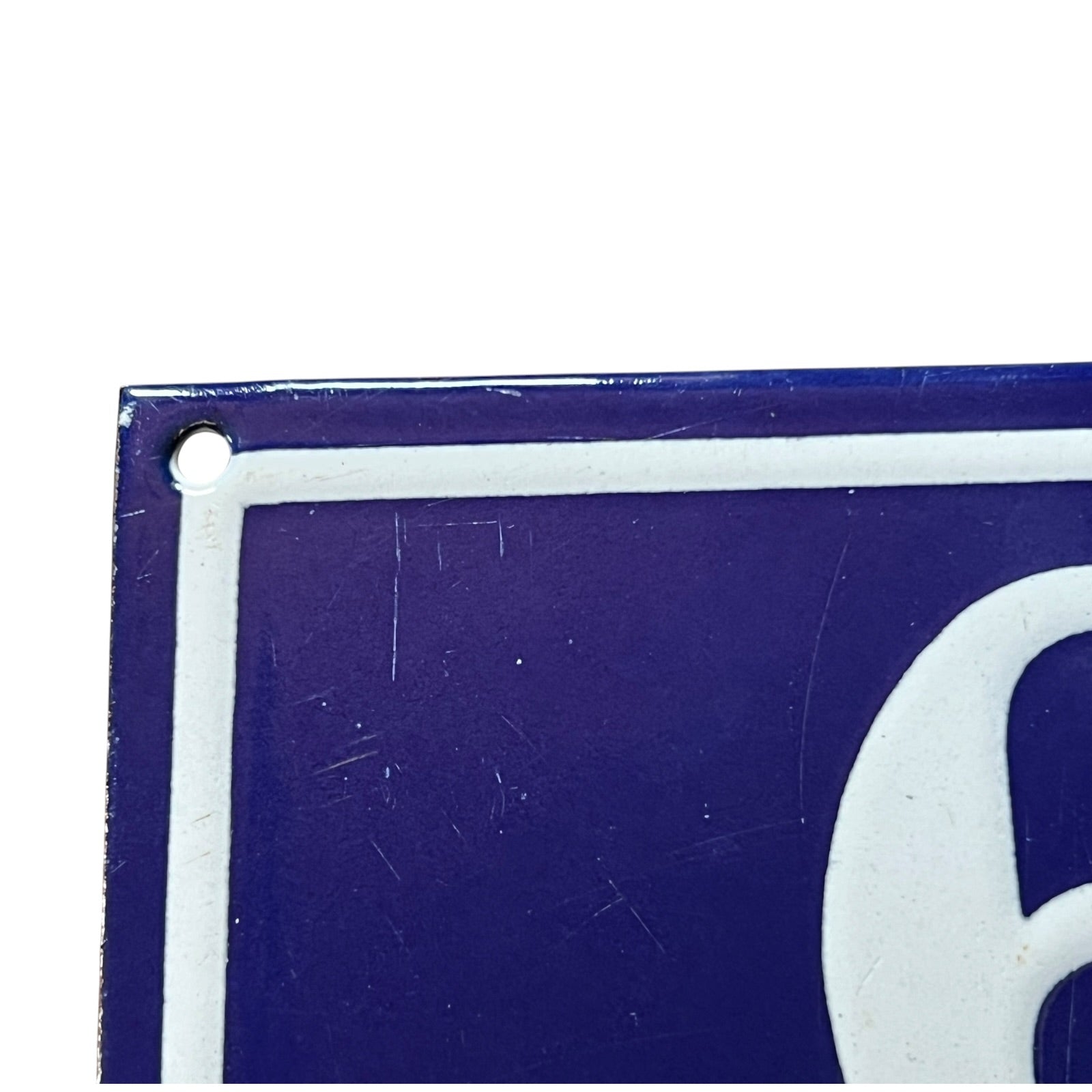 Close-up of a blue and white sign with a number '6' on a white background