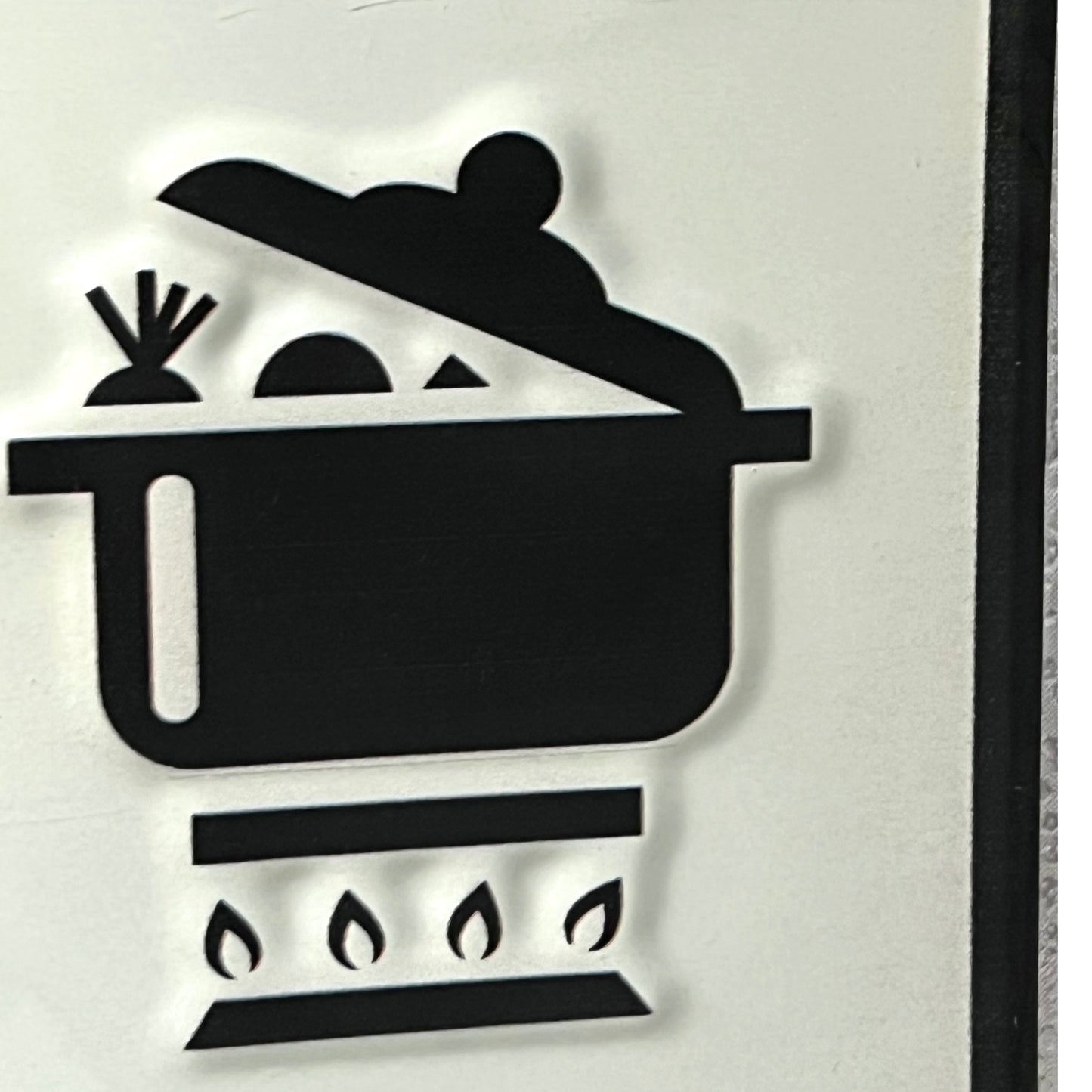 Black silhouette of a person cooking in a pot on a stove with flames.