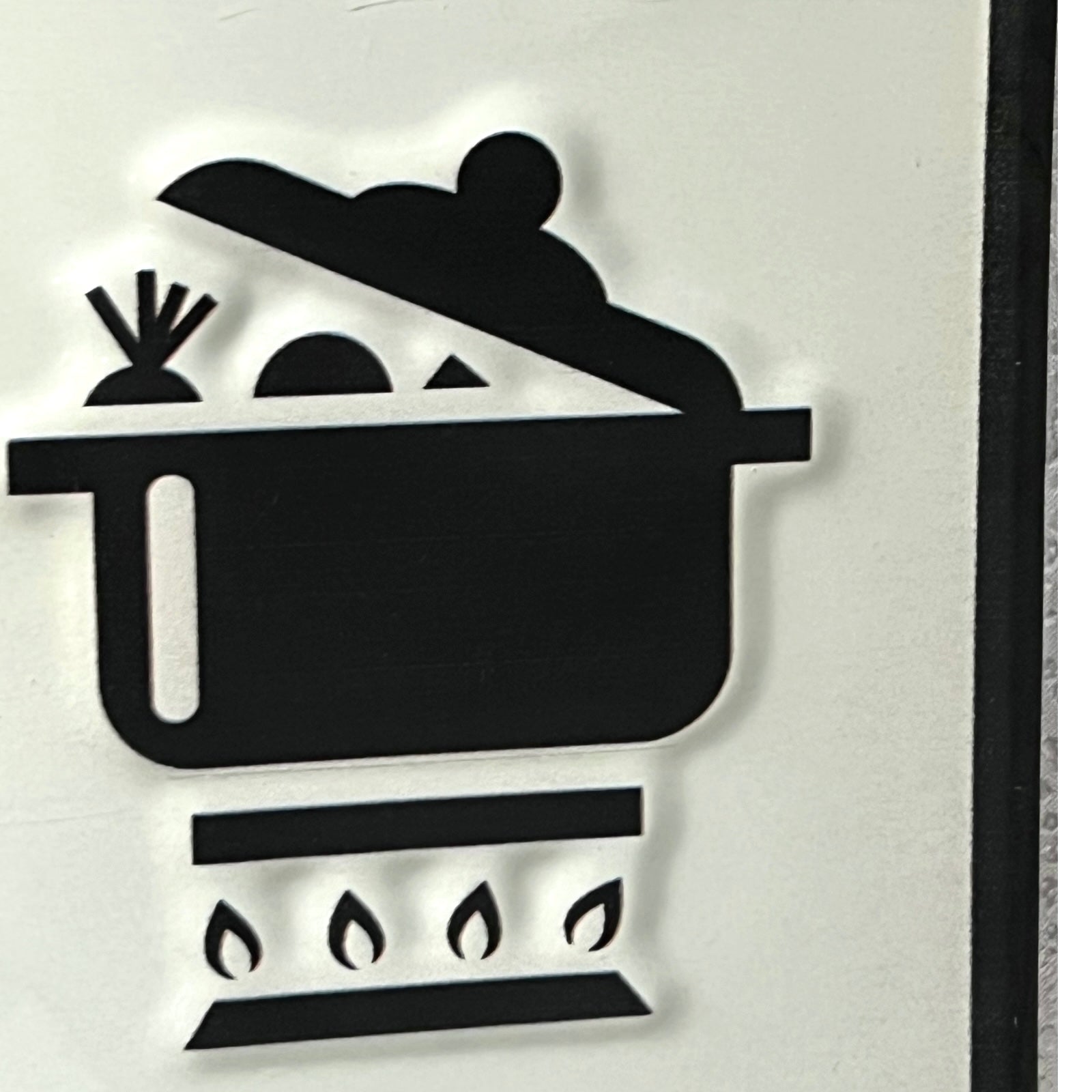 Black silhouette of a person cooking in a pot on a stove with flames.