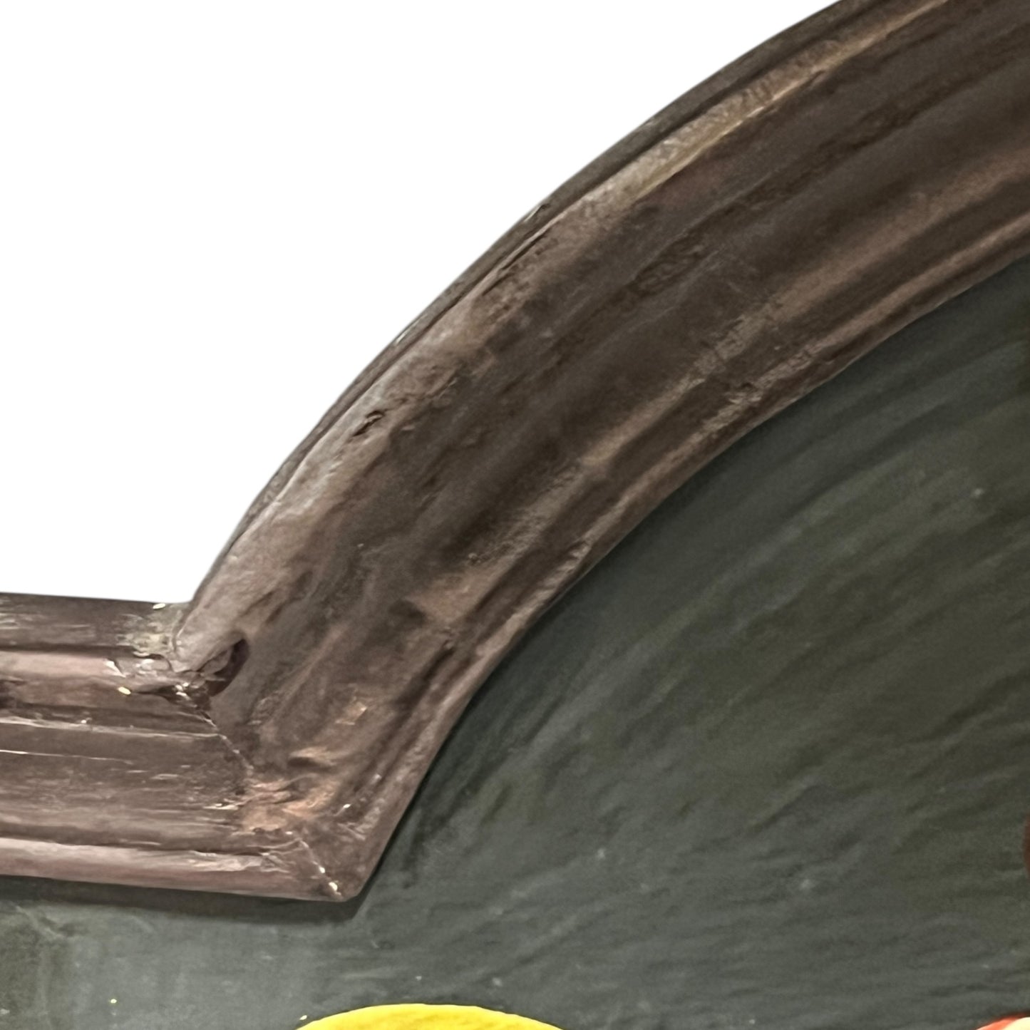 Corner of a framed picture with a dark brown frame and green interior.