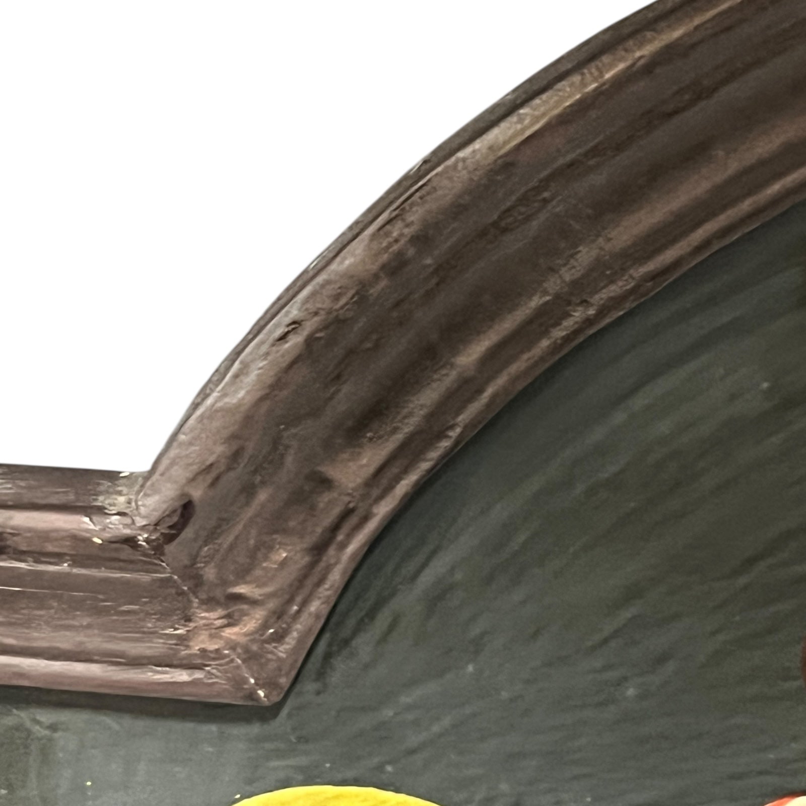 Corner of a framed picture with a dark brown frame and green interior.