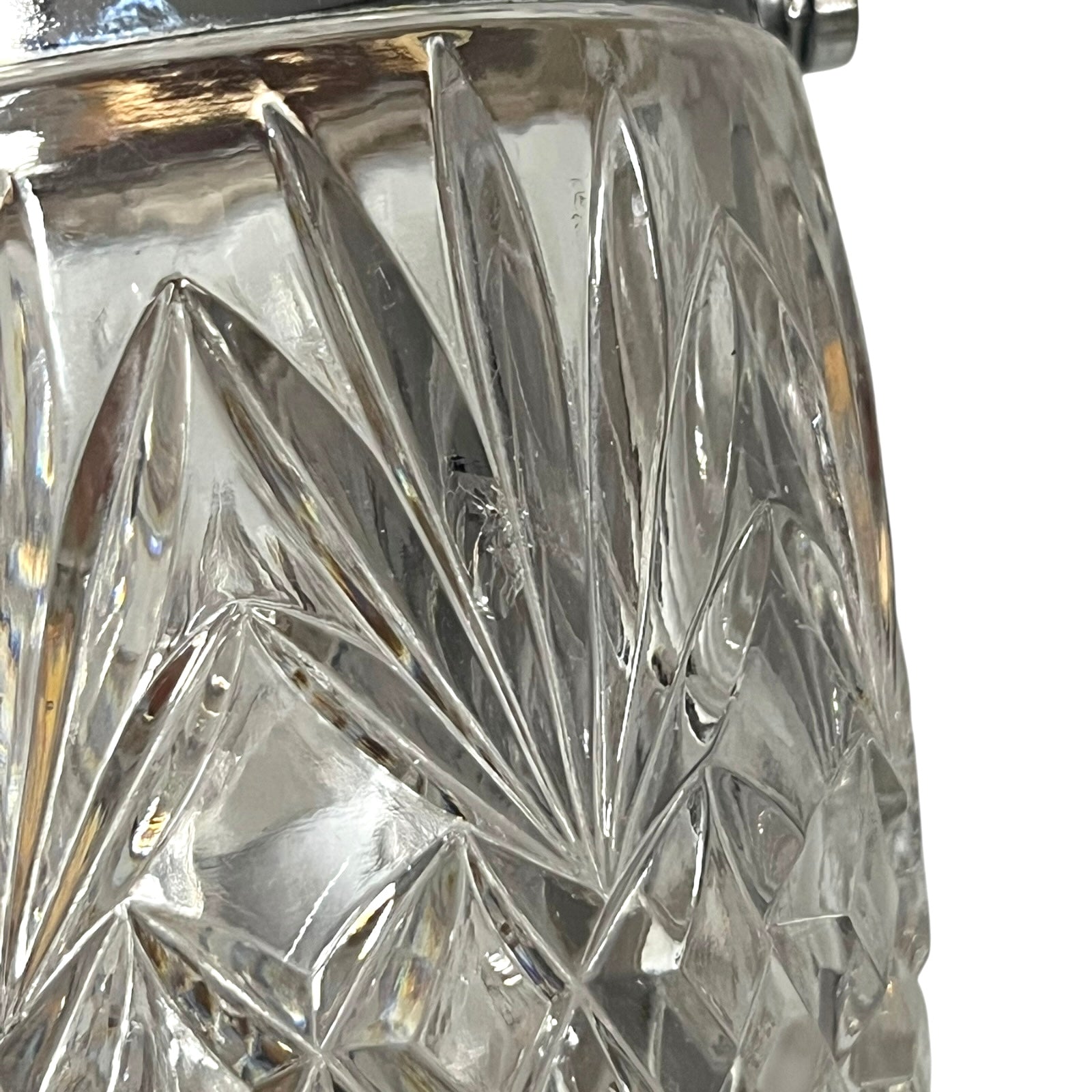 Close up of a French vintage glass ice bucket with silver rim on a white background