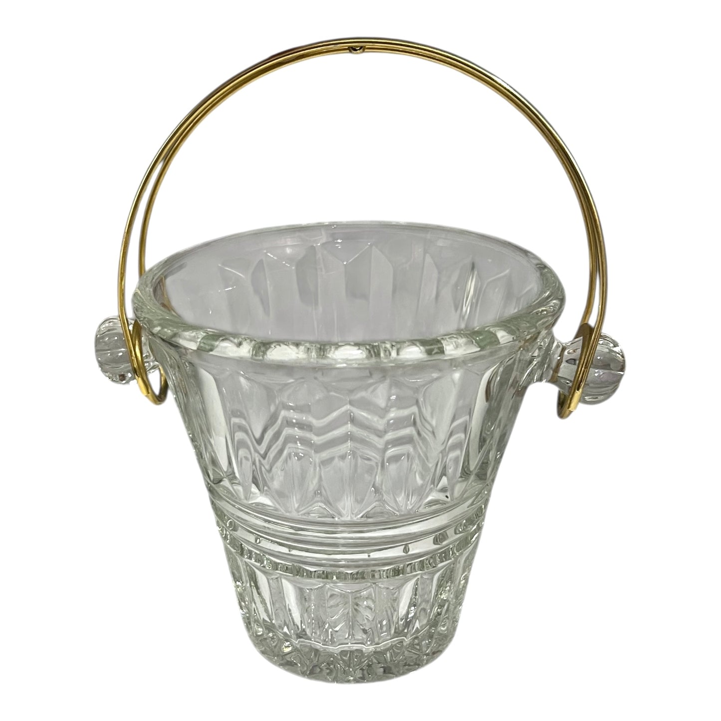 Clear glass ice bucket with gold handle on a white background