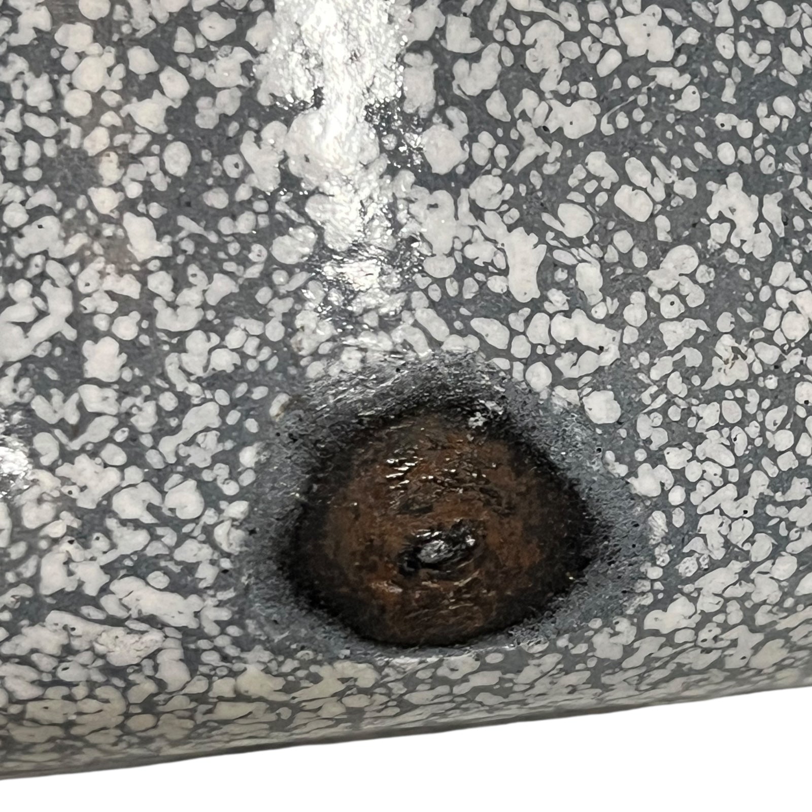close up of vintage French grey and white speckled irrigator with a spout and a handle showing wear and tear on a white background