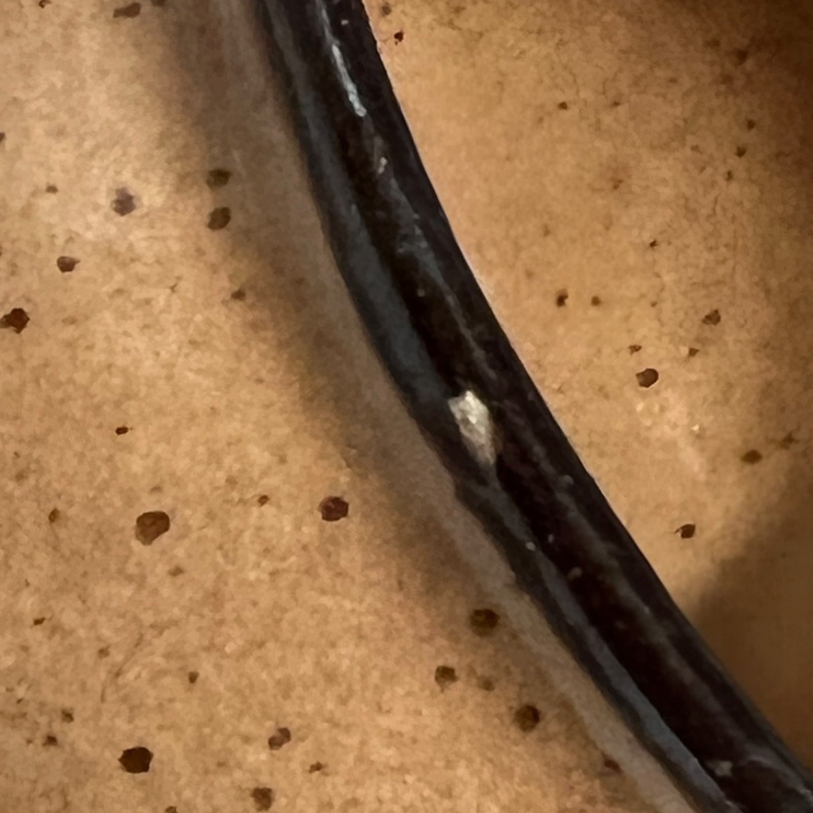 close up of soup bowl with lions head handles on a white background