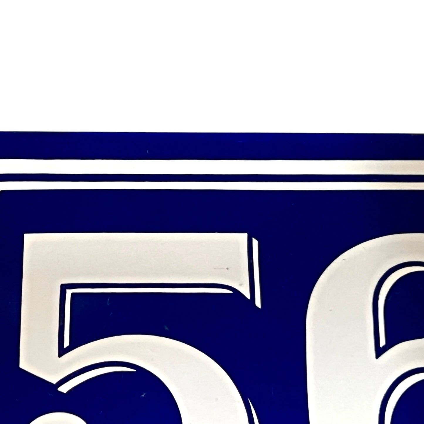Close-up of a blue and white number '56' on a white background