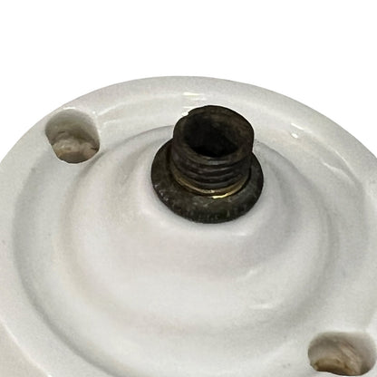 White French porcelain ceiling light rose fitting with a brass screw and 2 screw holes on a white background