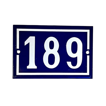 A rectangular blue house number plaque with white border and white numerals '189' on a plain white background.